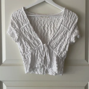 Vit topp - Gullig vit topp som man knyter från pull & bear. I storlek xs och i bra skick.