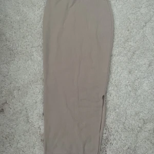 Lång kjol  - Beige/ljus rosa, kan ha både högmidjat och lågmidjat, slits vid ena sidan