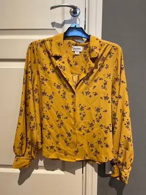 Blus från monki som jag inte använder längre! Tycker att färgen ser annorlunda ut på bilden- men den är mer senapsgul/orange och har rosa blommor! :>