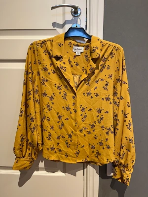 Monki blus - Blus från monki som jag inte använder längre! Tycker att färgen ser annorlunda ut på bilden- men den är mer senapsgul/orange och har rosa blommor! :>