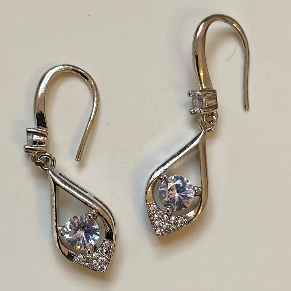 Små silverfärgade örhängen med rhinestones  Okänt material . Accessoarer.
