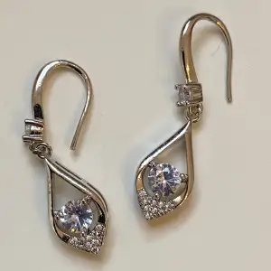 Små silverfärgade örhängen med rhinestones  Okänt material 