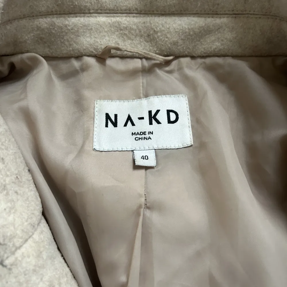 Hej! Jag säljer en beige kappa från NAKD! Den är i bra skick och har inga fläckar eller dylikt   Den är i storlek 40 men passar mig bra som oftast har storlek 36-38 i jackor.  . Jackor.
