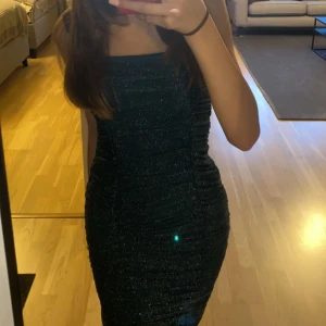 Glittrig klänning - Jätte fin glittrig klänning i mörkgrön färg i bra skick aldrig använt köpt för 750kr pris kan diskuteras!