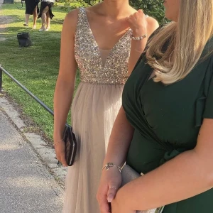 Jätteffin glittrig balklänning - Jättefin glittrig långklänning, passar perfekt till studentbal eller liknande. Storlek 34. Uppsydd efter mig 164 cm lång. I fint skick, saknas inga ”diamanter”. 