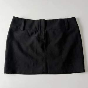 Lågmidjad svart kjol från Topshop i storlek 10 (M) men passar mer en S. Midjemått: 78cm. Längd: 33cm. Inga defekter :)