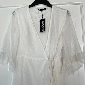 Vit omlottklänning - Jättefin somrig midi klänning. Aldrig använd, lappen sitter kvar. Från boohoo 