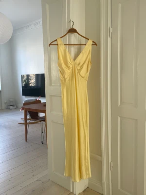 Långklänning siden - Fantastisk långklänning från asos i strl 38. Klänningen är i fint skick förutom en liten reva nedtill på baksidan samt en minimal fläck, också på baksidan. Detta är inget som syns när man har på sig klänningen. Jag är 178 lång och den går till vaderna. 