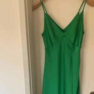 Grön satinklänning - Superfin klänning med slits, sitter snyggt på, har lite noppror vid magen(se bild! 