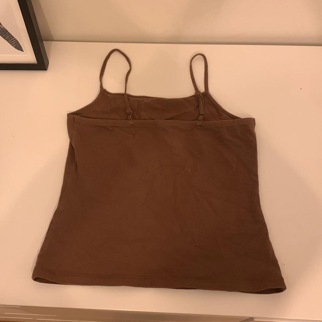 Brunt linne, inte lika lång som en t-shirt och inte som en magtröja med mittemellan. Bara använd några få gånger, jättebraskick.  - 90