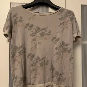 Blommig t-shirt med glittriga kanter, storlek 38. Säljs pga flytt!