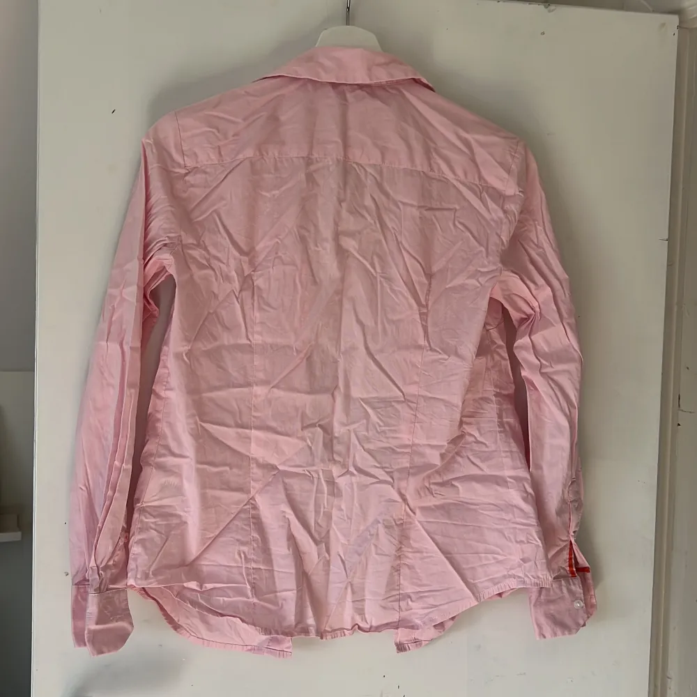 Rosa skjorta, köpt utomlands från märket STILE BENETTON. Tyvärr inte struken men väldigt fin när man strukit den. I nyskick. Stl 34. Skjortor.