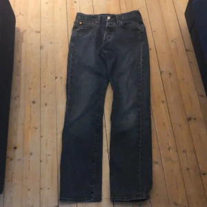 Svarta Levi’s 501 - Svarta/Mörkgråa Levi’s 501 i jättebra skick, nypris cirka 1300. Passformen är straight enligt mig. Säljer för att de börjar bli för små för mig, pris kan diskuteras.