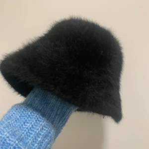 Fake fur mössa  - Använt några gånger. Toppskick. Spännbar därmed passar den alla huvudstorlekar.