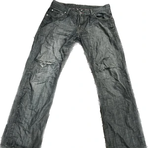 Tommy Hilfiger Retro Jeans - Väldigt unika oversized Hilfiger jeans i gråaktig färg. Hål vid knäna och slitage lite överallt.
