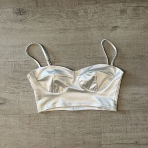 Vit topp stl XS - Säljer denna vita topp köpt från Nelly. Stl XS. Justerbara band. Använd en gång 