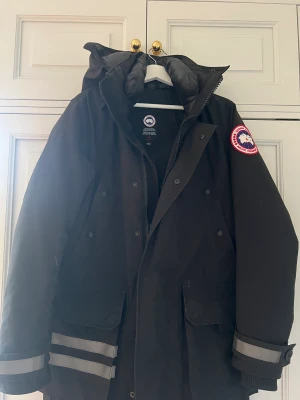 Canada Goose jacka - Canada Goose herr vinter jacka i storleken small. Den är stor, varm och skön. Perfekt för vintern. Den är svart i storleken Small men skulle också  funka för någon i med storleken Medium. Den här jackan köptes på nk för tre år sen för cirka 12000kr.