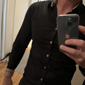 Burberry - Äkta Burberry skjorta , svart. Storlek S. För liten för mig så nu är det dags att sälja. Utan skador. Finns tyvärr inget kvitto då den är några år gammal. Nypris runt 5500