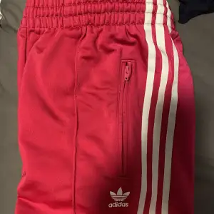 Vintage lågmidjade Adidasbyxor i rosaröd färg, beroende på ljus. Helt oanvända och därför i utmärkt skick, inga defekter! Skriv privat för fler bilder eller frågor💞