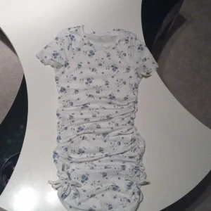 Blommig sommar klänning  - St146 blommig och har en rosett på sidan som jag visar på bild två