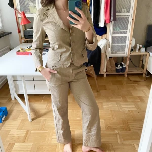 Kostym-Set - Svinsnyggt kostymset i asbra skick, säljer endast då byxorna är lite små!⭐️Den är i storlek S i ett beige-vit-randigt tyg och med massa knappdetaljer på fickor fram och bak!