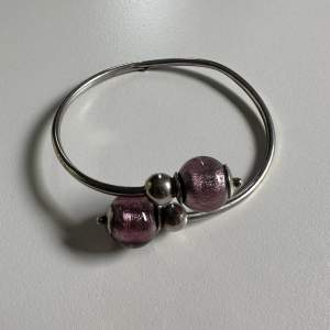 Silver bracelet with pink beads.