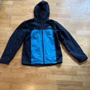 The North face vindjacka - Tjena, säljer nu min mörkblåa vindjacka från The North Face med ljusblåa detaljer. Storleken är medium och jackan är använd en del men i ett väldigt gott skick. Hör av dig vid funderingar, pris kan diskuteras 