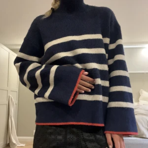 Randig tröja💗 - Säljer denna så snygga och unika stickade tröjan med hög krage! Den har så fina röda detaljer och vida armar💗tröjan är i så bra skick och använd ett fåtal gånger!