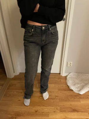 Lågmidjade Raka mörk-grå jeans  - Lågmidjade mörk grå jeans med slitningar längst ner. Dem är långa och raka i modellen. Från Gina, Storlek 40 (rätt små i storleken)  Använda endast ett fåtal gånger!
