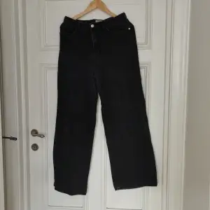 Svarta jeans i modellen wide/loose fit säljes. Jeansen är använda men i fint skick! Något slitna längst ner på benen