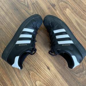 Svarta Adidas Superstar i stl 37 1/3🖤 Jag säljer dessa då de är för små för mig. Annars är skorna helt felfria med lätta tecken på användning! Orginal pris: 1 299 kr