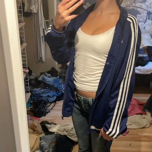 Stor adidas zipup tröja - Perfekt tröja/zipup/hoodie till hösten, från adidas! Köpt second hand, enda defekten är ett hål på ena axeln som jag knappt märkt av. Jag brukar bära xs-s och är 168 cm lång för referens! Fungerar även som en mycket tunn jacka. Använd inte köp direkt!!!