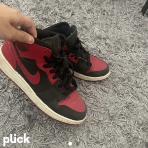 Jordans - Jordan 1 mid (banned) skor, snygga till alla outfit säljer pågrund av att jag inte fått någon användning av skorna. Självklart äkta och går lätt att rengöras! 