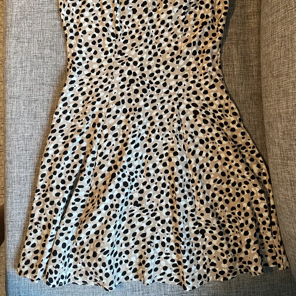 Light pink, with black and white polka dots. Short in length. Tight around the breast and waist area. Thin material. Worn once. Good condition.. Klänningar.