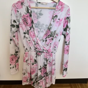 En blommig jumsuit  - Säljer en blommig jättesöt jumpsuit från Nelly. Storlek S 