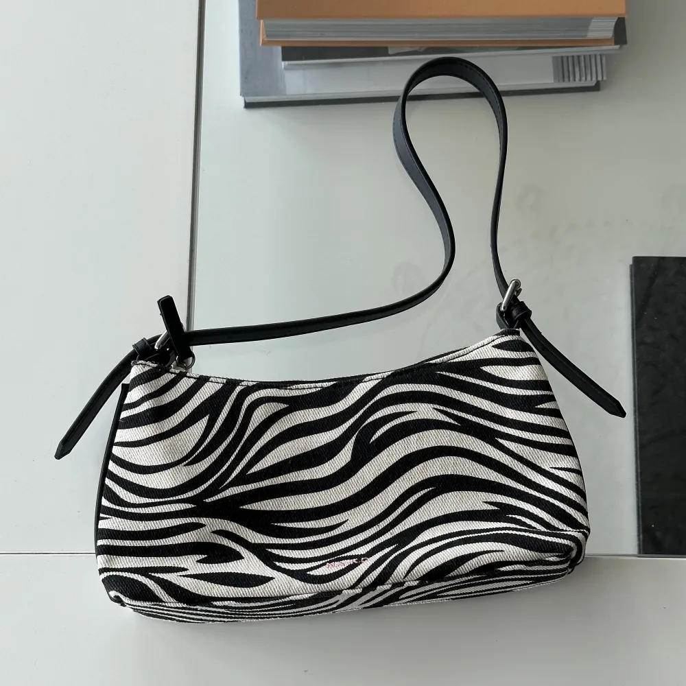 Väska i canvas från NA-KD, snyggt zebramönster och silvrig hårdvara. Aldrig använd, bara varit med på bild 🤍. Väskor.