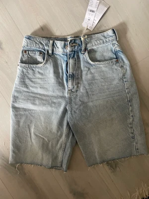 Jeansshorts  - Ljusblåa jeansshorts från Gina. Helt oanvända och lappen sitter fortfarande kvar. Går till strax över knäna. 