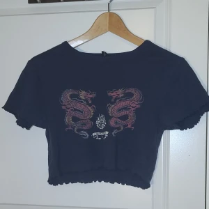 Babytee från urban outfitters - Mörkgrå babytee med tryck från urban outfitters. Storlek S