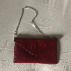 Denna röda lilla väska kommer inte till användning hos mig så säljer den nu. Väldigt fint mönster och färgen är lite mörkare irl. Kedjan är utbytbar och den som sitter på nu är inte original. Har ett stort fack