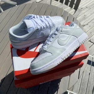 Nike Dunk Low ”Photon Dust” - Säljer dessa Nike Dunk Low ”Photon Dust”. De är helt nya och oanvända. Köpta på JD och är äkta. Finns i storlek 36-39. Vissa storlekar är det några dagar längre leveranstid på. Använd gärna köp nu funktionen men Swish funkar också.