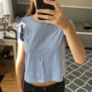 Söt topp från Zara - Säljer denna söta topp i en jättefin blå färg från Zara. Den har tyvärr en liten defekt längre ner vid kantsömmen men den är inget synligt. 