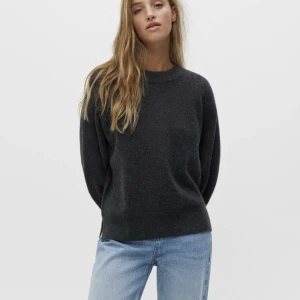 Mörkgrå stickad tröja - Mörkgrå stickad tröja i boxigare modell. Tröjan har en liten slits nertill på varje sida. Tröjan är oanvänd. Från pull&bear storlek S. 