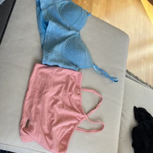 Glitter topp - Två glittertoppar en blå och en rosa. Båda är kroppade en med band som korsas och en med kupor.  Skriv privat för mått 