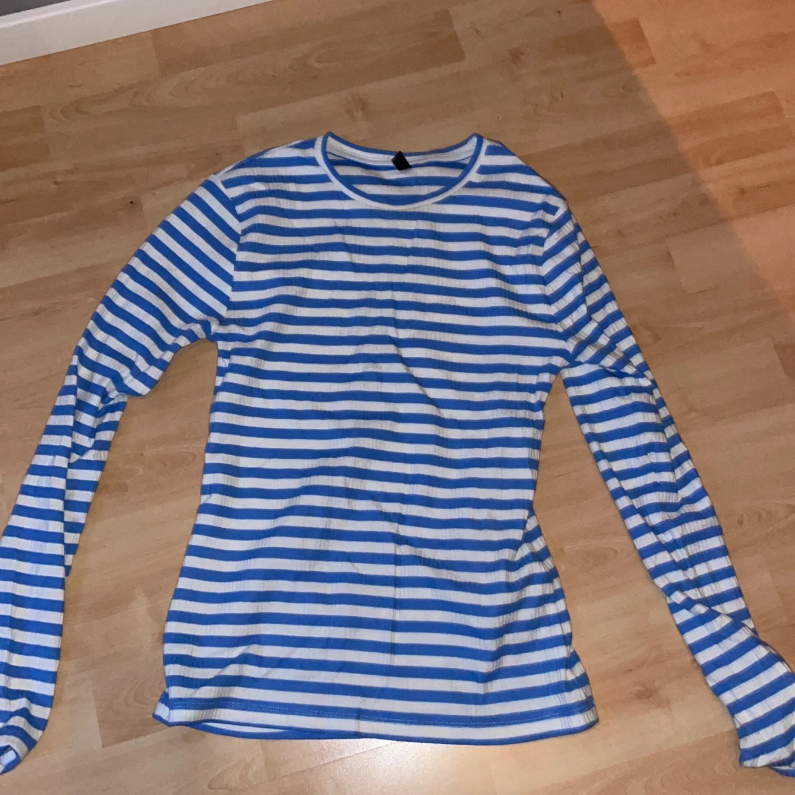 Långärmad tröja som är ribbad med vita och blåa ränder