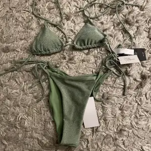 Superfin grön glittrig bikini från nakd x Moa Matsson. Helt oanvänd med taggarna och trosskyddet kvar. Storlek S 