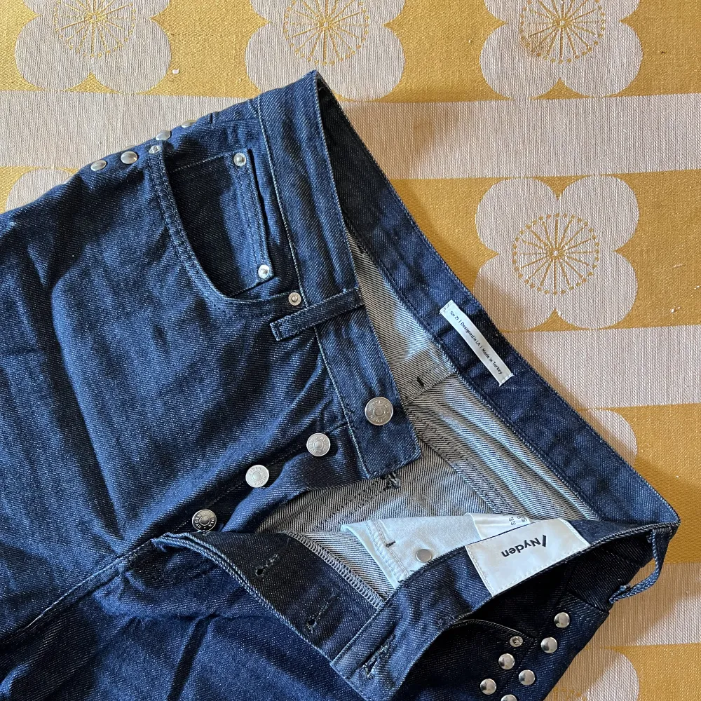 Vida extra långa jeans med nitar längs hela sidorna. Marinblå med en svag metallisk känsla. Höga i midjan och ett skönt material. Inga skador.. Jeans & Byxor.