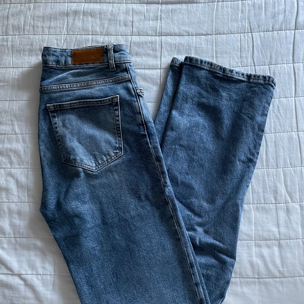 Jeans i super snygg blå färg ifrån bikbok modellen är rak och mid/highwaist . Jeans & Byxor.