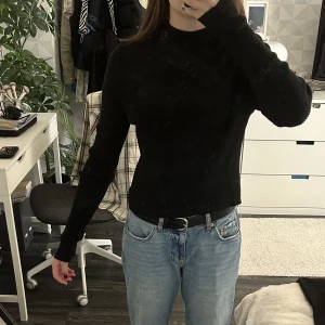 Tröja  - Säljer min svarta tröja ribbad och långärmad med knytningar på ryggen och polokrage, den är i bra skick, från GinaTricot i storlek M😊