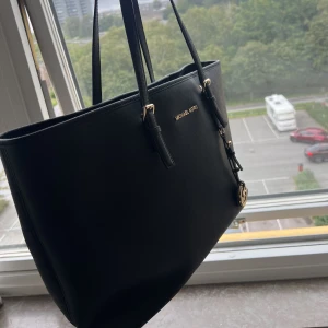 Michael Kors väska - En ny svart Michael Kors väska.  Väskan har inte kommit till användning och är i nytt skick.  Perfekt inför skolstarten.  Pris kan diskuteras vid snabb affär 