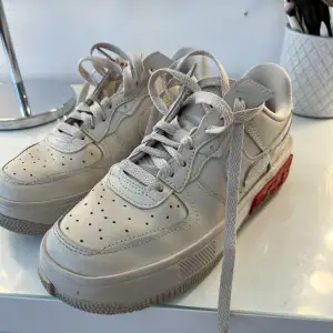 Beigea Nike air force skor med röda detaljer! Använda 3 gånger så dem är i väldigt fin skick, säljer dem nu pga kommer aldrig till andvändning, storlek 38!!